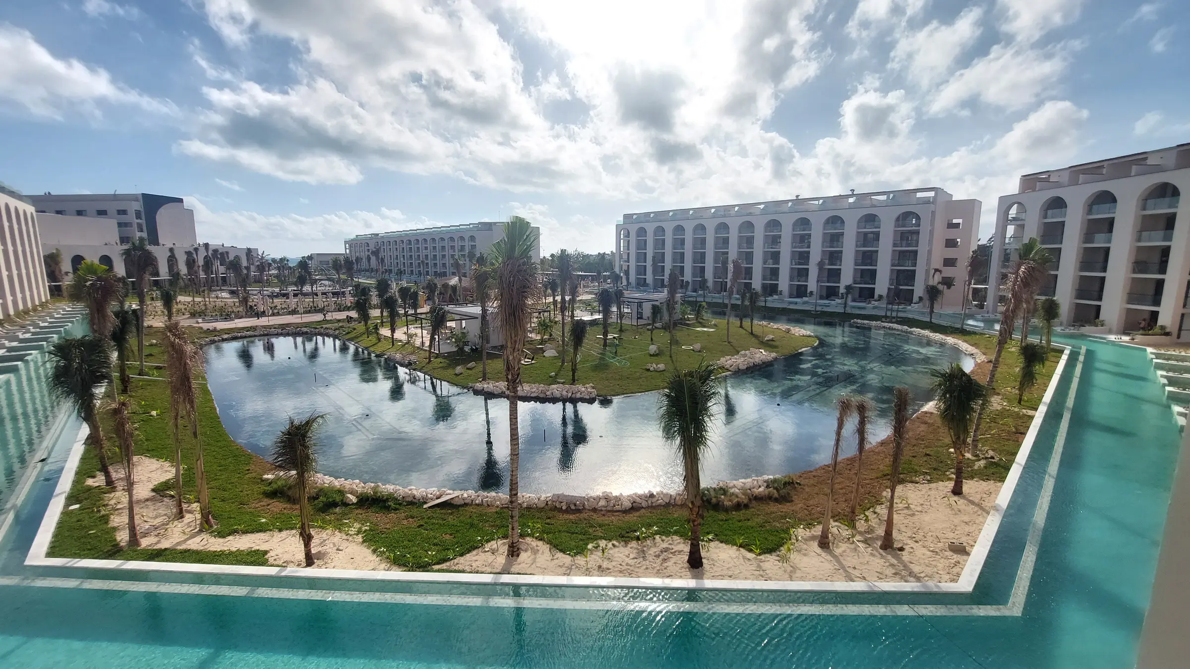 Resort en obra en la Riviera Maya, con la alberca principal y los edificios de habitaciones